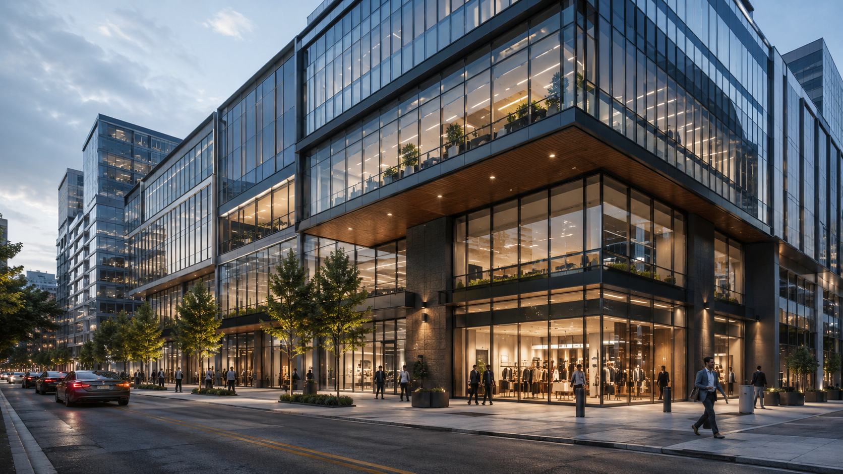 Modern glass commercial building at dusk with street-level retail.